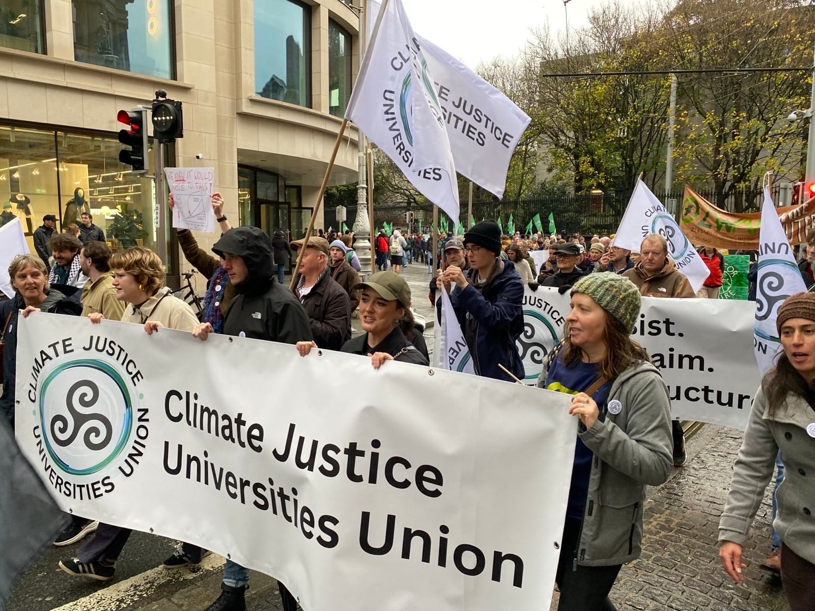 Photograph of CJUU marchers, with flags and banners, on the streets of Dublin.